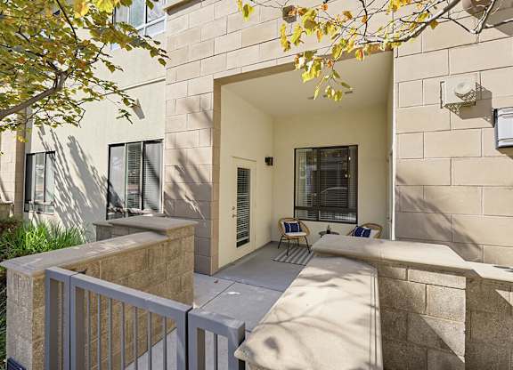A modern house with a stone wall and a white fence.
