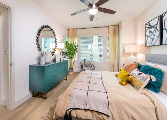 Sepia Design Package Bedroom with ceiling fan and large window at The Seaton Apartments in San Diego CA