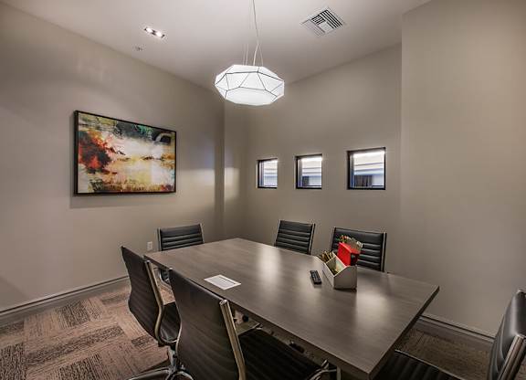 A conference room with a large table and chairs.