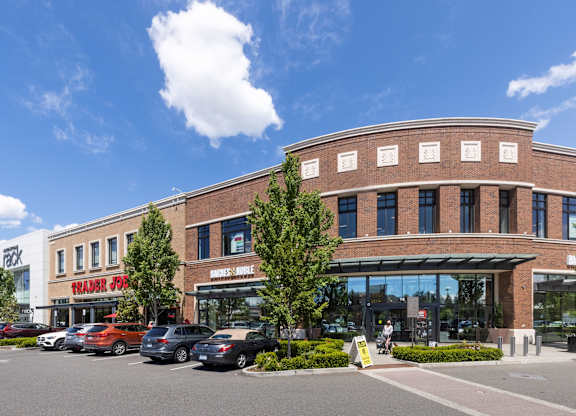 A parking lot with cars and a building with a sign that says