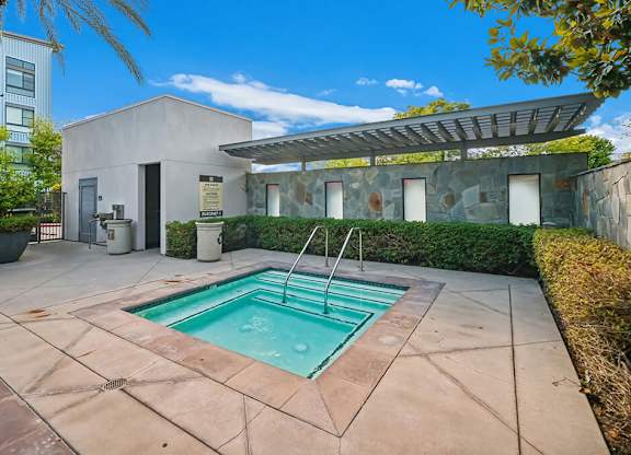 A small pool in a patio with a building in the background.