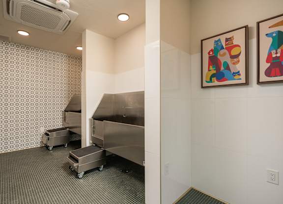 A room with two pieces of artwork on the wall and a stainless steel dishwasher.
