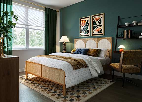 A bedroom with a bed, chair, and lamp.