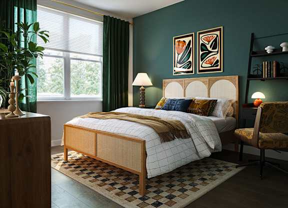 Bedroom with green accent wall at Merrick on Midway Apartments in Farmers Branch TX