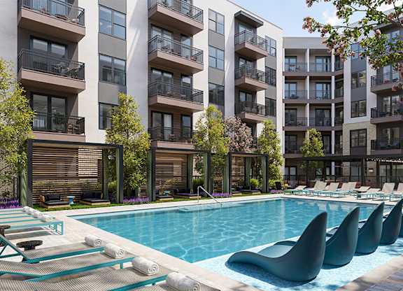 Outdoor pool and chairs at Merrick on Midway Apartments in Farmers Branch TX