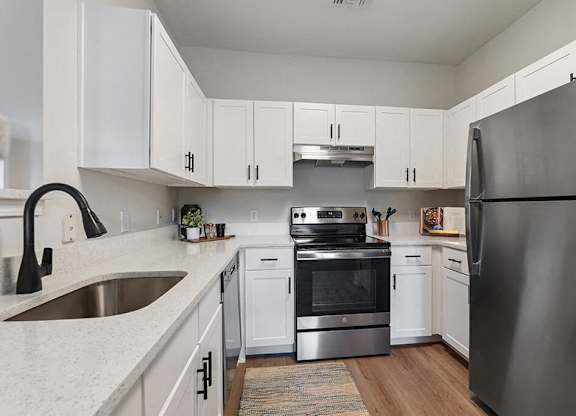a kitchen with stainless steel appliances and white cabinets