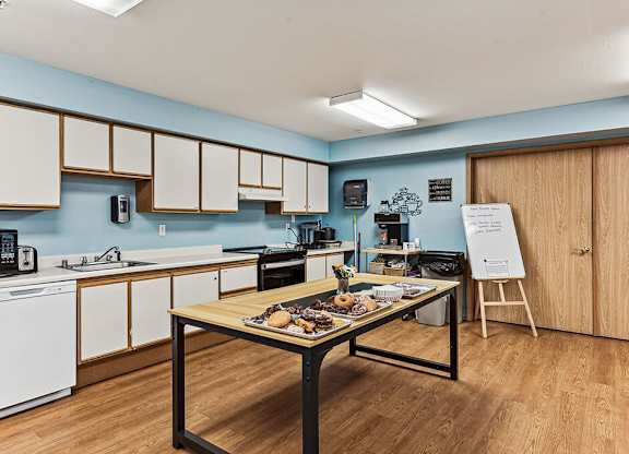 A kitchen with a table in the middle of it.