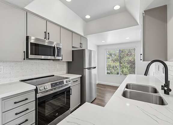 A modern kitchen with a stove, oven, and refrigerator.