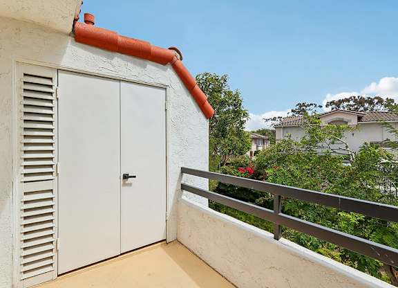 A white door with a red trim is on the side of a building.