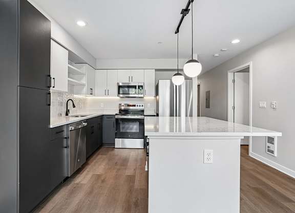 A modern kitchen with a white island and stainless steel appliances.