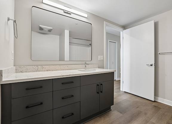 A bathroom with a marble countertop and a large mirror.