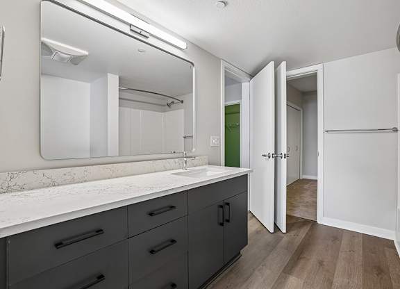 A bathroom with a marble countertop and a large mirror.