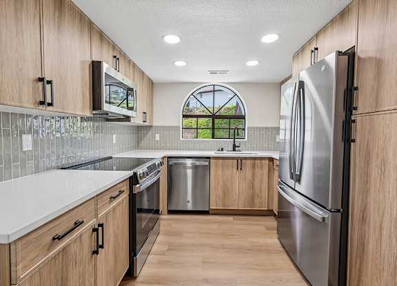 A kitchen with wooden cabinets and stainless steel appliances.