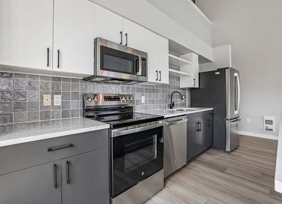 A modern kitchen with a stove top oven and microwave above it.
