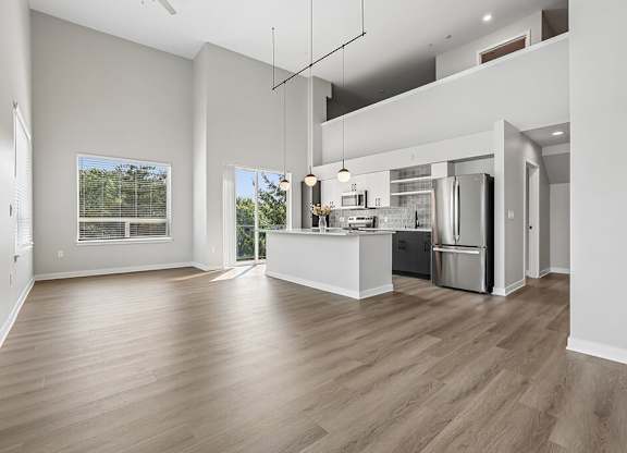 A modern kitchen with a wooden floor and white walls.