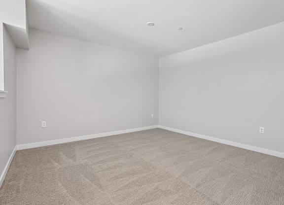 A room with a carpeted floor and white walls.