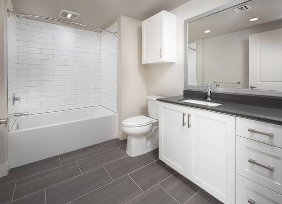 Slate design package bathroom with shower tub combo at The Seaton Apartments in San Diego CA