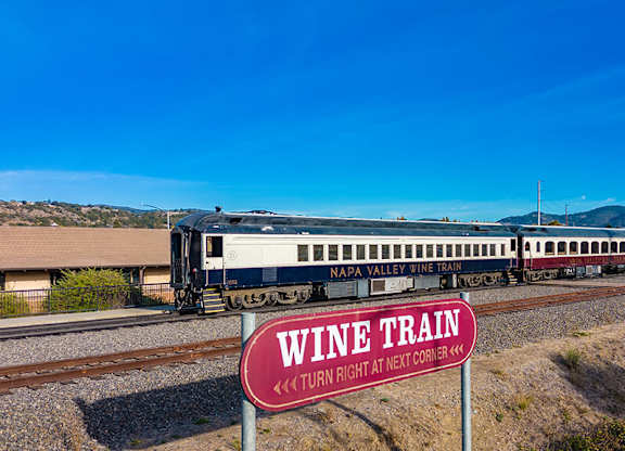 A train with a sign that says Wine Train is on the tracks