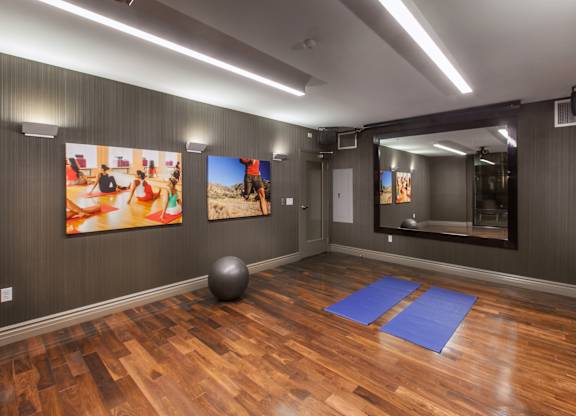 A room with wooden floors and a large mirror on the wall.