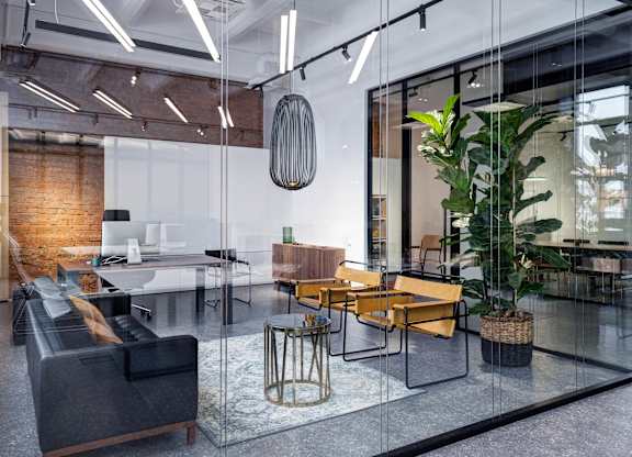 A modern office space with glass walls, a glass table, and a glass floor.