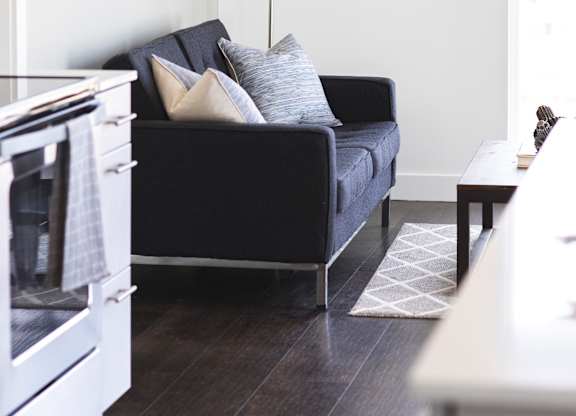 A black couch with pillows sits in a living room.