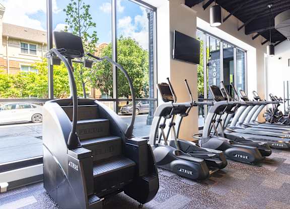 A gym with a variety of cardio equipment including treadmills and elliptical machines.