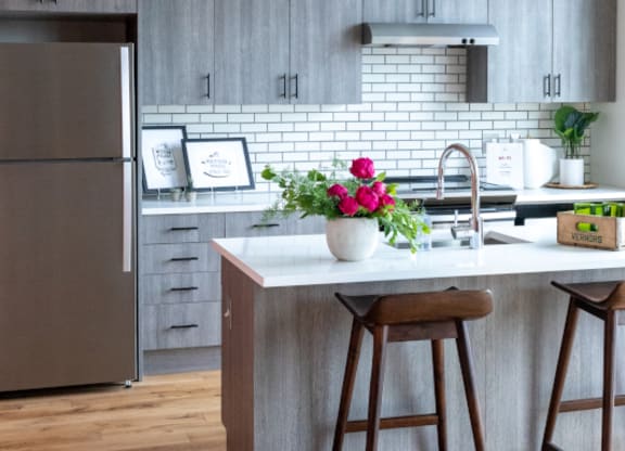 Kitchen with Island and Grey Cabinets at The Assembly, Detroit, MI