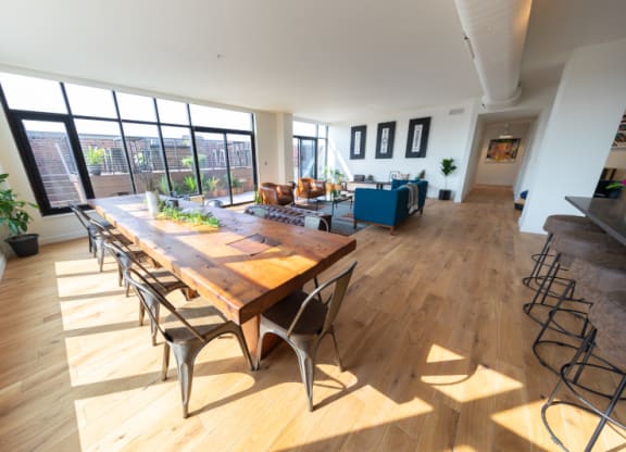 Large Wooden Table with Chairs near a Large Window at The Assembly, Detroit 