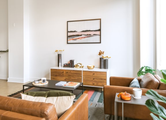 a living room with white walls and brown leather furniture  at The Ferguson, Michigan