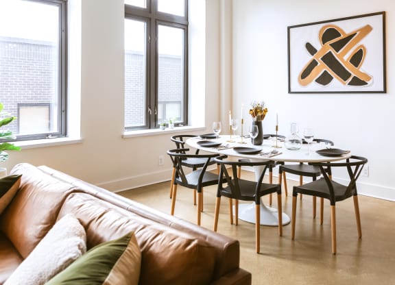 a dining room with a table and chairs and a couch in a 555 waverly unit at The Ferguson Apartments, Detroit, Michigan