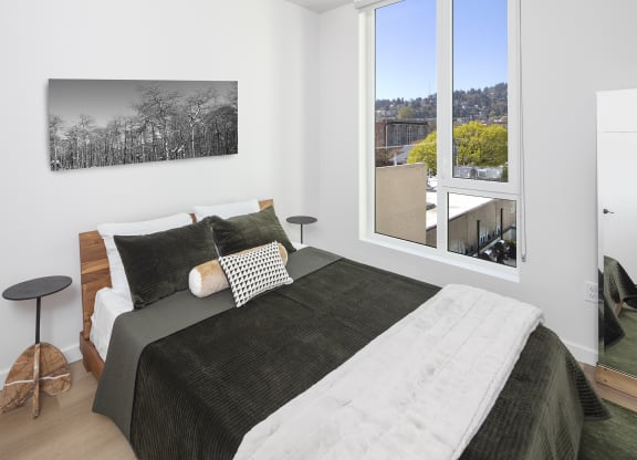 a bedroom with a bed and a large window at The Weidler in Portland, OR 97209