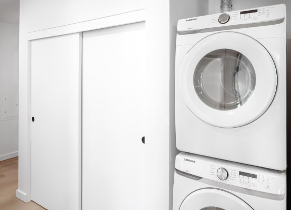 a white washer and dryer in a white laundry room at The Weidler in Portland, OR 97209