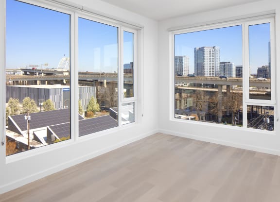 a living room with four windows and a city view at The Weidler in Portland, OR 97209