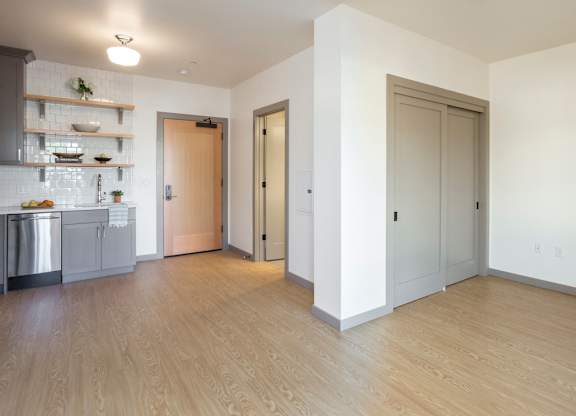 A kitchen with a refrigerator, sink, and cabinets.