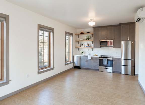 A kitchen with wooden floors and stainless steel appliances.