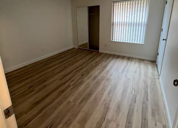an empty living room with hardwood floors