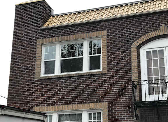 A brick building with a window and a balcony.
