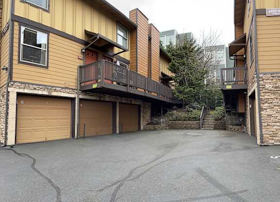 a driveway with two garages in front of a house