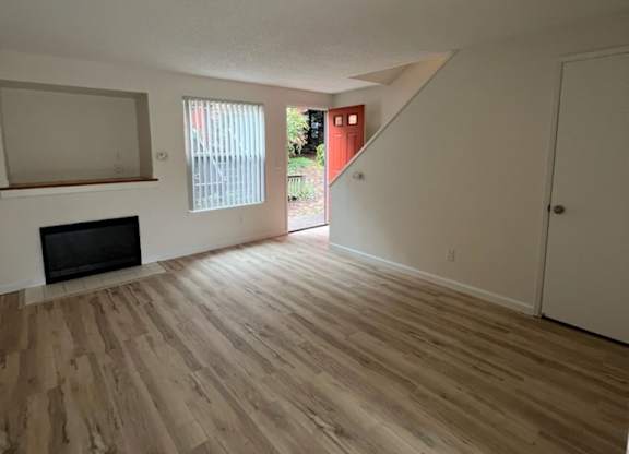 an empty living room with hardwood floors