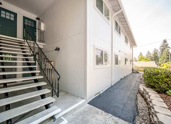 A white building with a black railing staircase.