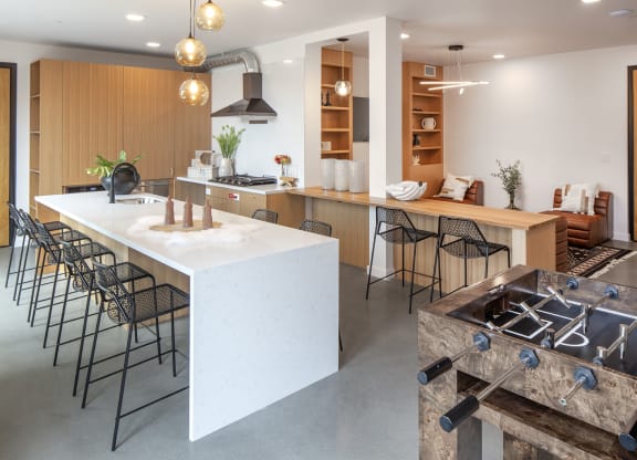 the kitchen and dining area of a modern house with a large white island and chairs at The Weidler in Portland, OR 97209
