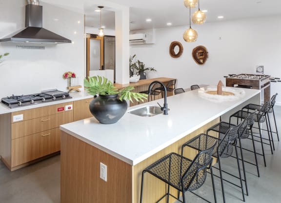 a large kitchen with an island and black bar stools at The Weidler in Portland, OR 97209