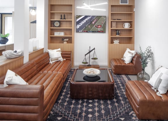 a living room with brown leather couches and a table at The Weidler in Portland, OR 97209