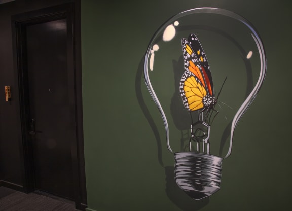 a painting of a butterfly inside of a light bulb at The Weidler in Portland, OR 97209