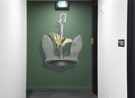 a painting of a flower on a wall next to a urinal at The Weidler in Portland, OR 97209