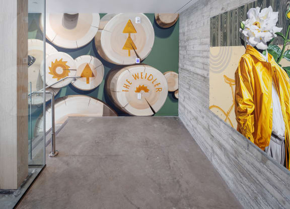 a hallway with a statue of a monk in a yellow robe and a wall with at The Weidler in Portland, OR 97209