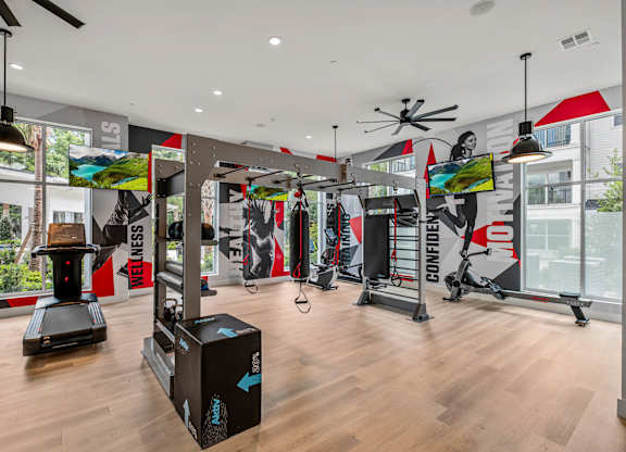 A gym with a variety of equipment including treadmills, weights, and exercise machines.