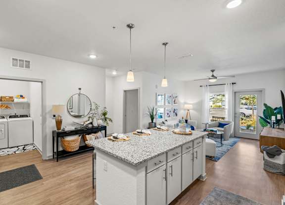 A modern kitchen with white cabinets and a large island.at Altis Grand Lake Willis, Orlando