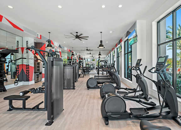 a gym with cardio equipment and windows in a building at Altis Grand Suncoast, Land O' Lakes Florida