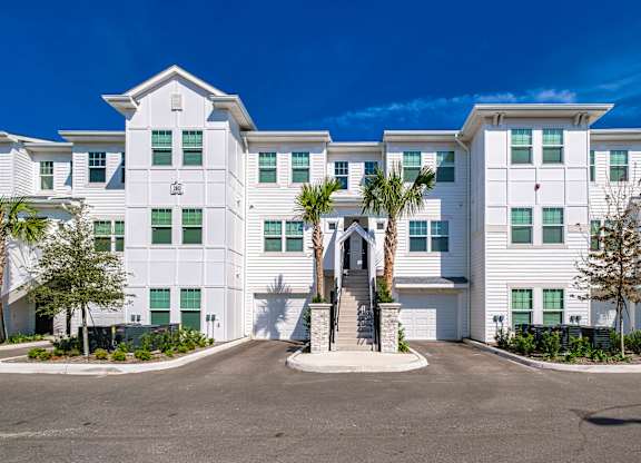 a large white building with palm trees in front of it at Altis Grand Suncoast, Land O' Lakes, 34638
